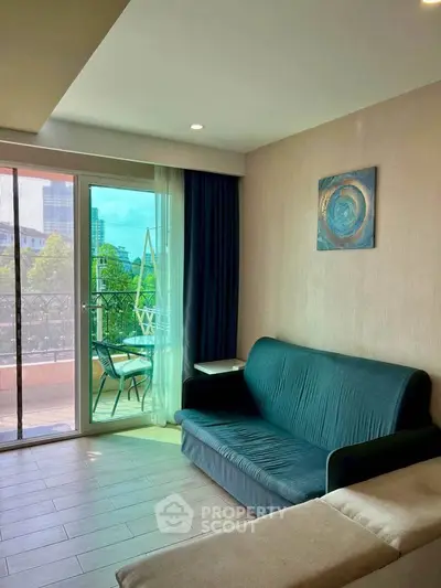 Charming living room with balcony access and city view, featuring cozy seating and modern decor.