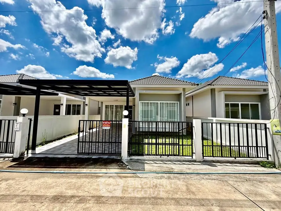 Charming single-story house with modern design and spacious driveway under a bright blue sky.