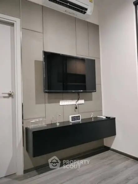 Modern living room with wall-mounted TV and sleek black console
