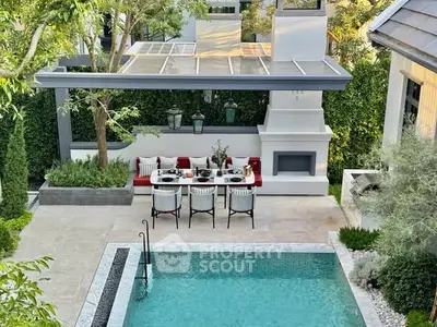 Luxurious outdoor dining area with pool and modern pergola, perfect for entertaining.