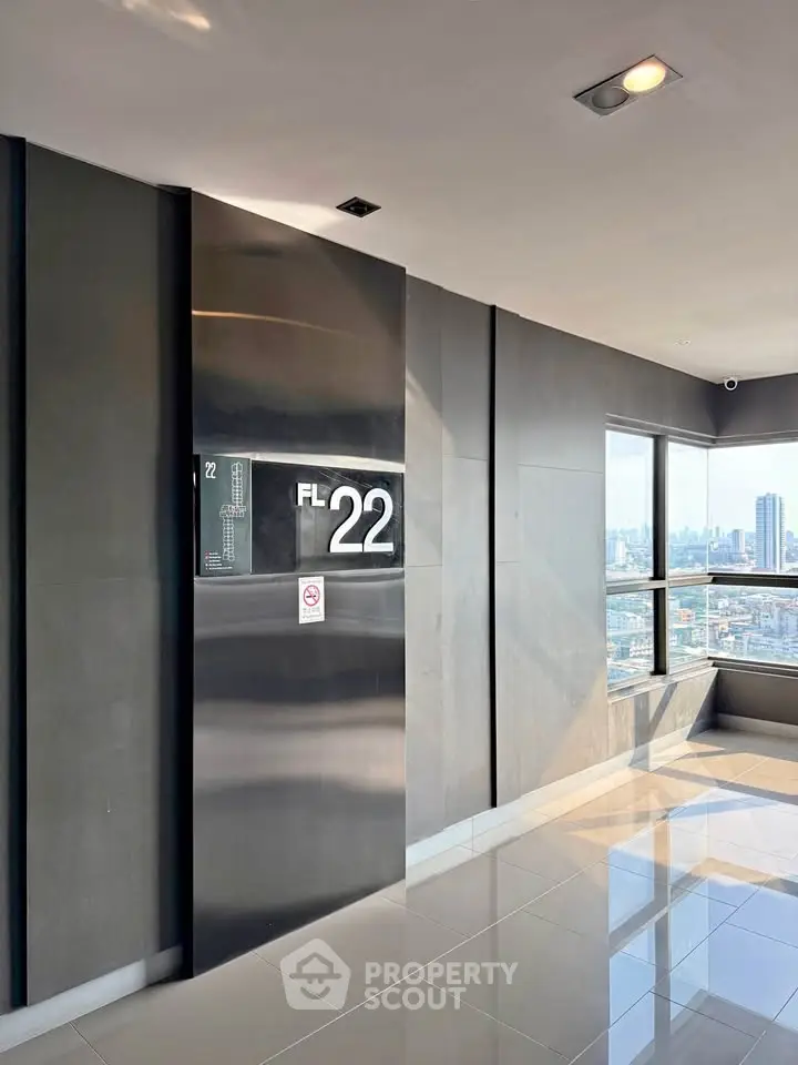 Modern high-rise building corridor with city view from floor 22, featuring sleek design and large windows.