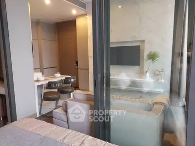 Modern living room with sleek furniture and dining area in open layout apartment.