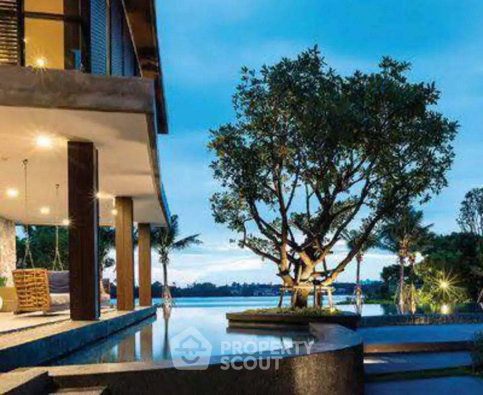 Luxurious modern villa with stunning pool and serene lake view at dusk.