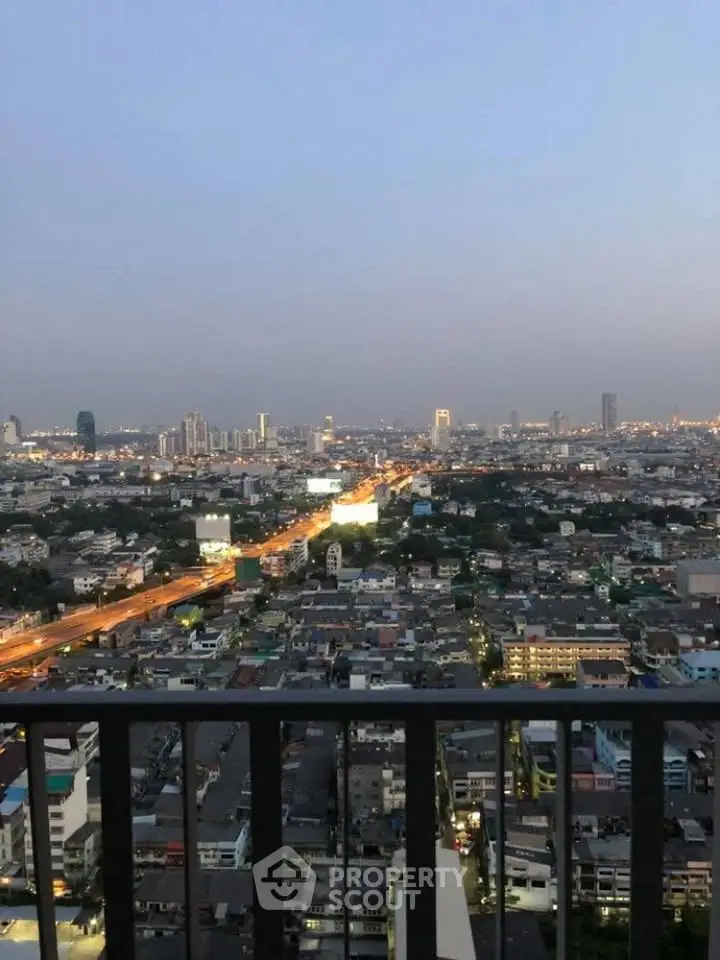 Stunning cityscape view from a high-rise balcony at dusk, showcasing vibrant urban lights.