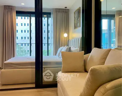 Modern bedroom with glass partition and cozy seating area in urban apartment.