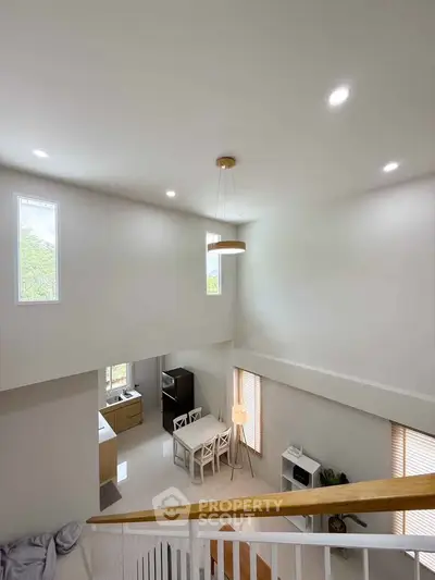Spacious modern living room with high ceiling and natural light
