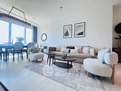 Spacious modern living room with elegant decor and large windows offering natural light.