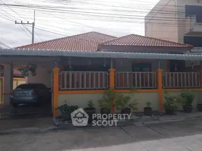 Charming single-story house with tiled roof and carport in a suburban neighborhood.