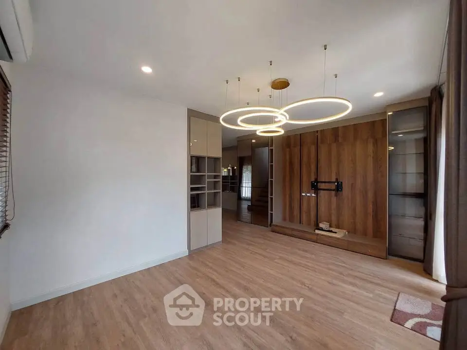 Spacious modern living room with elegant lighting and wooden flooring, perfect for stylish living.