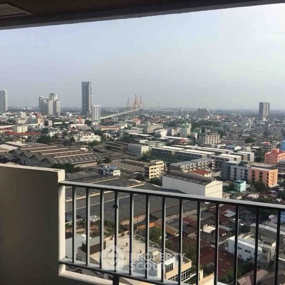 Stunning cityscape view from high-rise balcony overlooking urban skyline and iconic bridge.