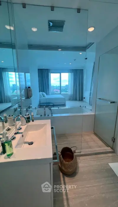 Modern bathroom with glass shower and city view from window