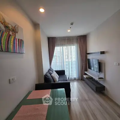 Modern living room with stylish decor and large window offering natural light.