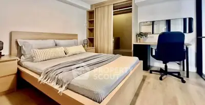 Modern bedroom with stylish decor and spacious layout, featuring a comfortable bed and sleek workspace.