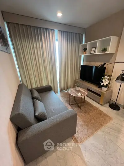 Cozy living room with modern decor, featuring a comfortable sofa, TV, and stylish shelving.