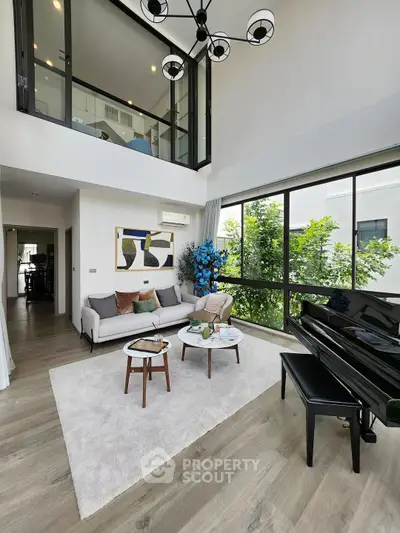 Spacious modern living room with high ceilings and large windows, featuring elegant decor and a grand piano.