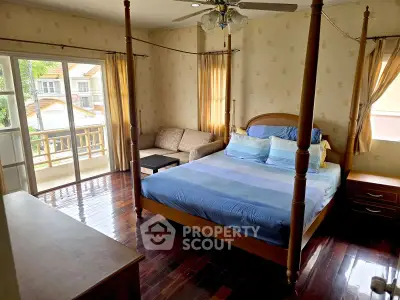 Spacious bedroom with four-poster bed and balcony access in a cozy home.