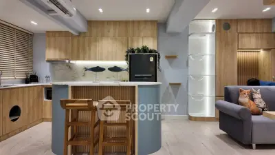 Modern kitchen with wooden cabinetry and sleek island in stylish apartment.