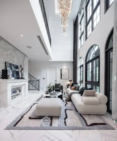 Luxurious living room with high ceilings, elegant chandelier, and modern decor in a spacious open layout.