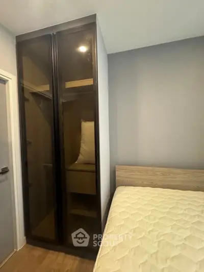 Modern bedroom with sleek glass wardrobe and cozy bed