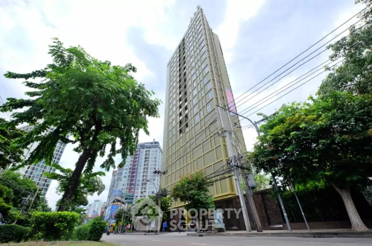 Stunning high-rise building with modern architecture in urban setting, surrounded by lush greenery.