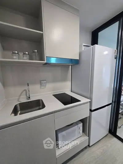 Modern compact kitchen with sleek appliances and minimalist design