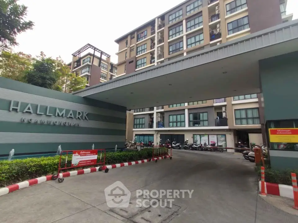 Modern apartment building entrance with sleek design and lush greenery