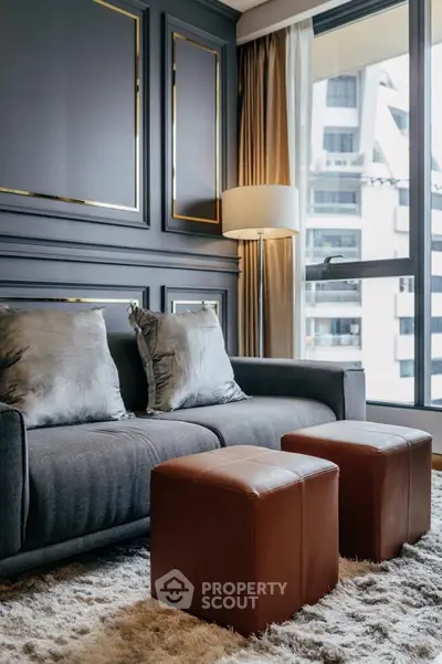 Luxurious living room with elegant gray sofa and modern decor in high-rise apartment.