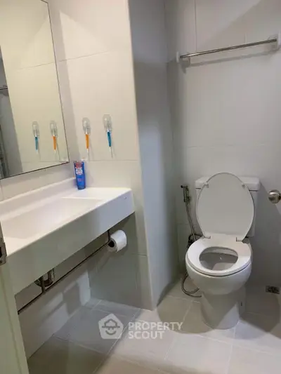 Modern bathroom with sleek fixtures and a clean design, featuring a wall-mounted sink and toilet.