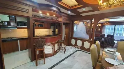Luxurious open kitchen and dining area with elegant wooden finishes and modern appliances