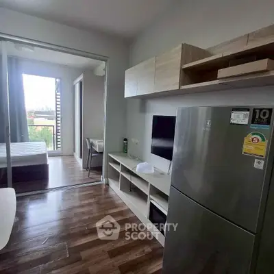 Modern apartment interior with open kitchen and cozy living area, featuring sleek appliances and stylish decor.
