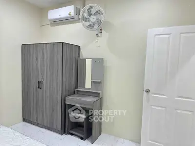 Modern bedroom with sleek wardrobe and vanity set, featuring air conditioning for comfort.