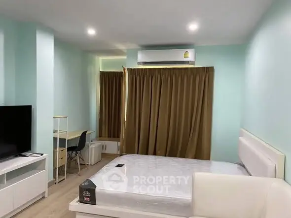 Modern bedroom with minimalist design, featuring a bed, TV, and study desk.