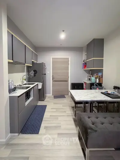 Modern kitchen with sleek cabinetry and dining area in stylish apartment