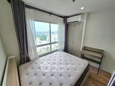 Bright bedroom with large window and city view, featuring a comfortable bed and air conditioning.