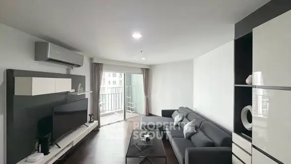 Modern living room with sleek furniture and balcony access in a stylish apartment.