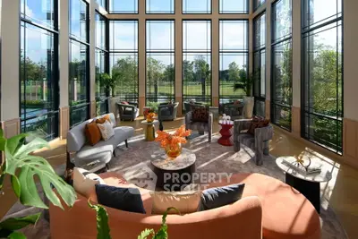 Luxurious living room with floor-to-ceiling windows and elegant seating, offering stunning garden views.