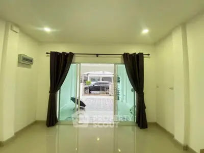 Spacious living room with sliding glass doors leading to a modern patio area.