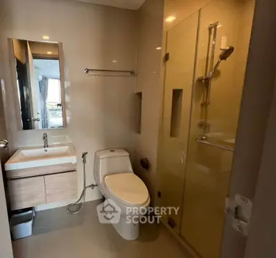Modern bathroom with sleek fixtures and glass shower in contemporary apartment.