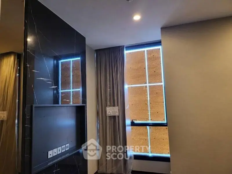 Modern interior with marble accent wall and large windows in luxury apartment.