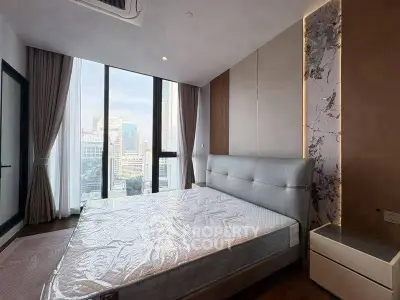 Luxurious bedroom with floor-to-ceiling windows offering stunning city views, modern design and elegant decor.