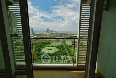 Stunning cityscape view from a high-rise balcony with lush greenery and skyline.