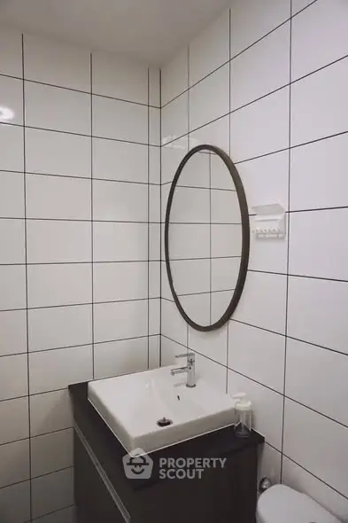 Modern bathroom with sleek sink and round mirror, perfect for minimalist design lovers.