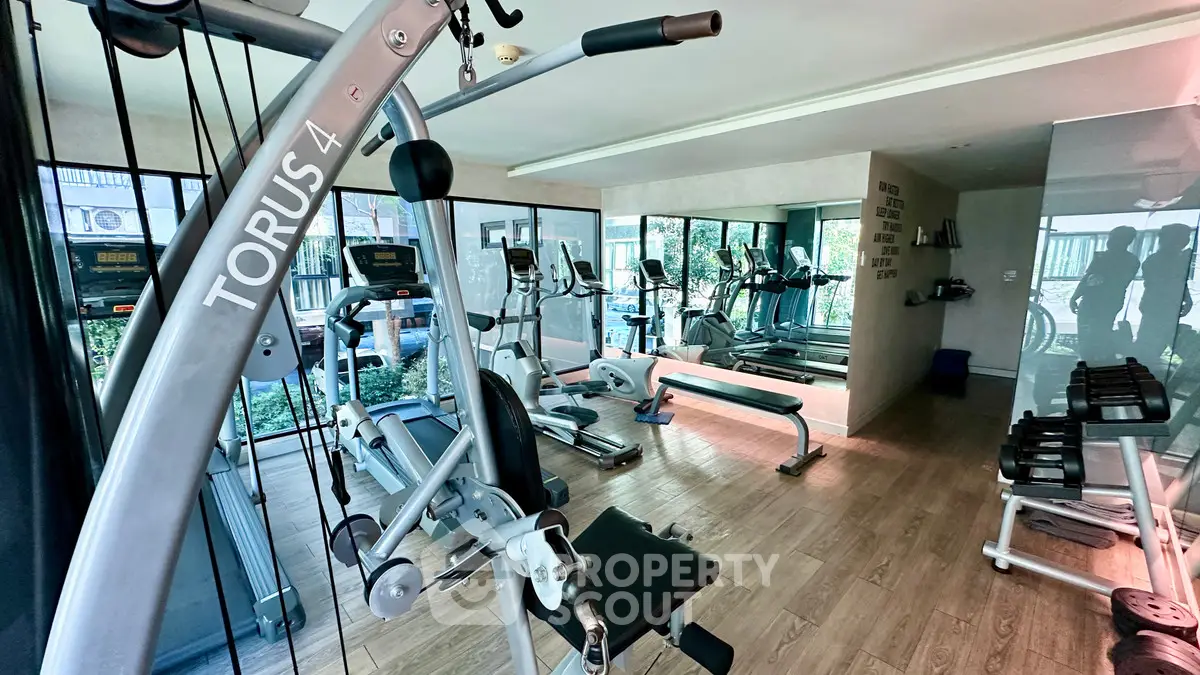 Modern gym with state-of-the-art equipment and mirrored walls in a luxury building.