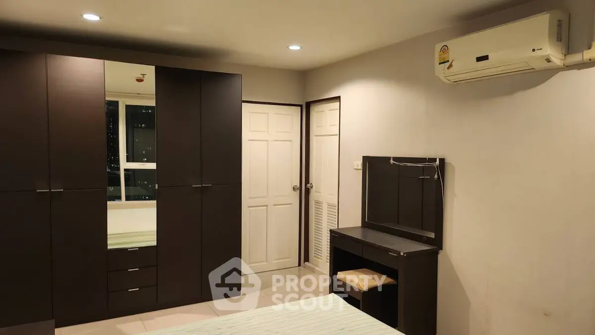 Spacious bedroom with modern furniture and air conditioning, ideal for comfortable living.