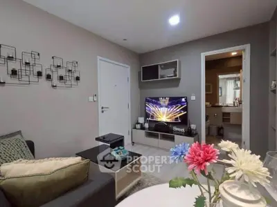 Cozy living room with modern decor and TV, adjacent to a stylish bathroom.