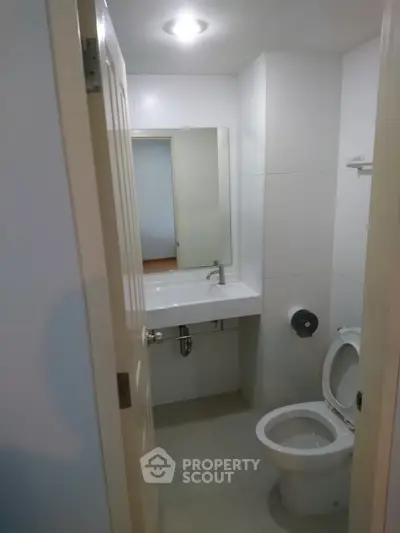 Compact bathroom with modern fixtures and white tiles