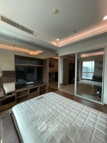 Modern bedroom with mirrored wardrobe and cozy lighting in a high-rise apartment