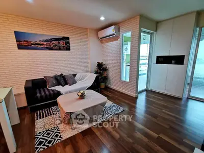 Modern living room with stylish decor and balcony access, featuring hardwood floors and cozy seating area.