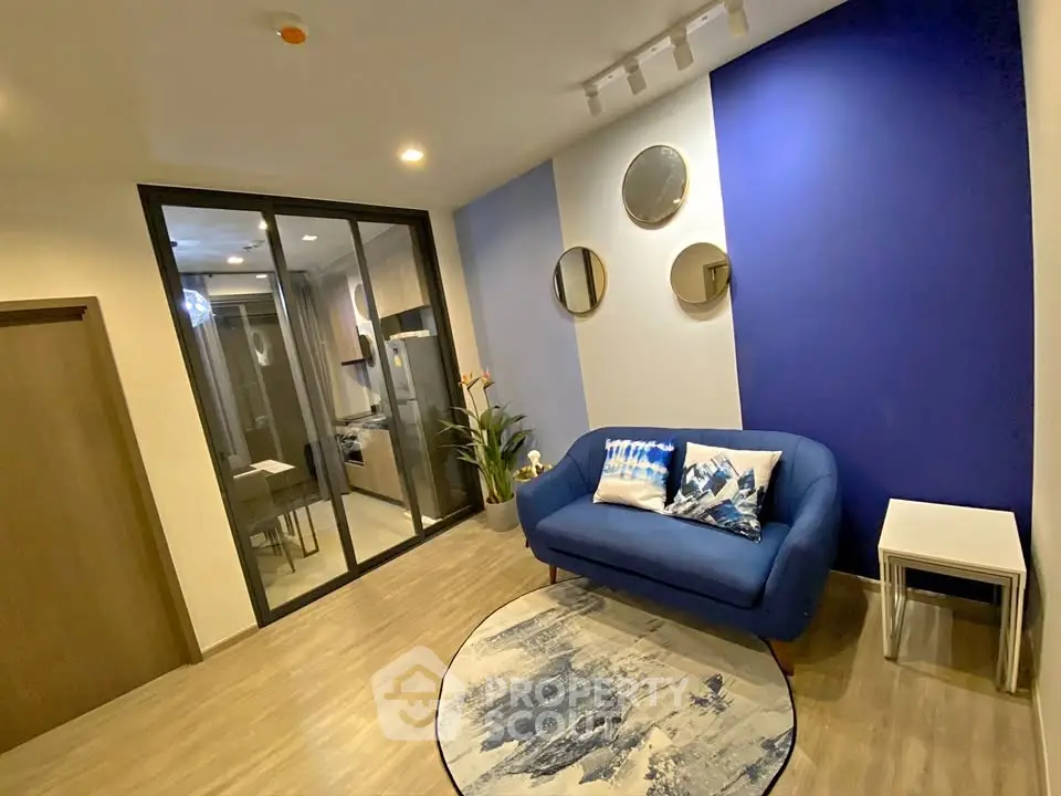 Modern living room with blue accent wall and stylish decor in a cozy apartment.
