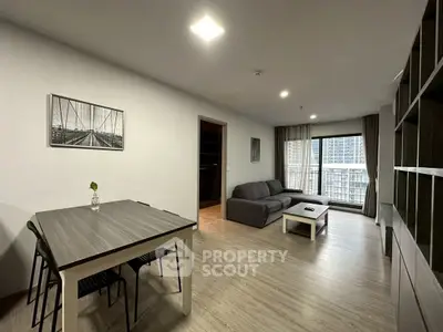 Modern living room with stylish furniture and large windows offering city views.